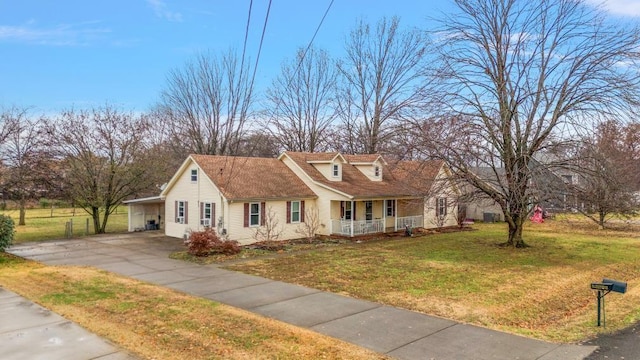 new england style home with covered porch, a front lawn, and a carport