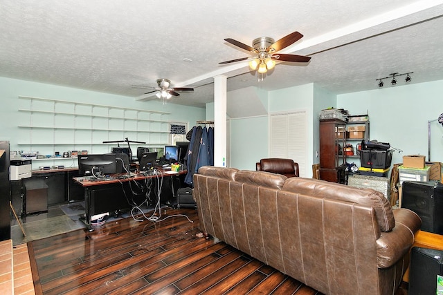 living room featuring ceiling fan, dark hardwood / wood-style flooring, and a textured ceiling