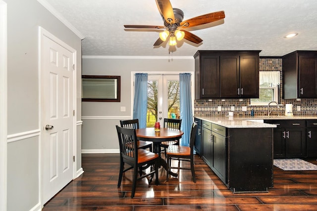 kitchen with dark brown cabinets, french doors, dark hardwood / wood-style floors, and ornamental molding