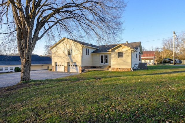 view of front facade with french doors, a garage, and a front lawn