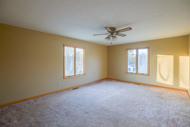 carpeted empty room featuring a textured ceiling and ceiling fan