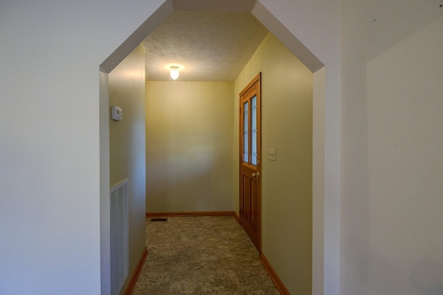 hallway with a textured ceiling