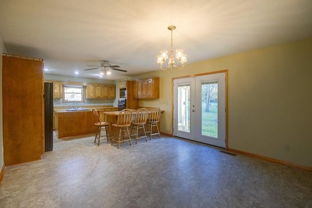 kitchen with a healthy amount of sunlight, a kitchen bar, kitchen peninsula, and backsplash