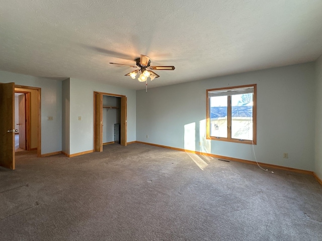 unfurnished bedroom featuring carpet, a textured ceiling, and ceiling fan