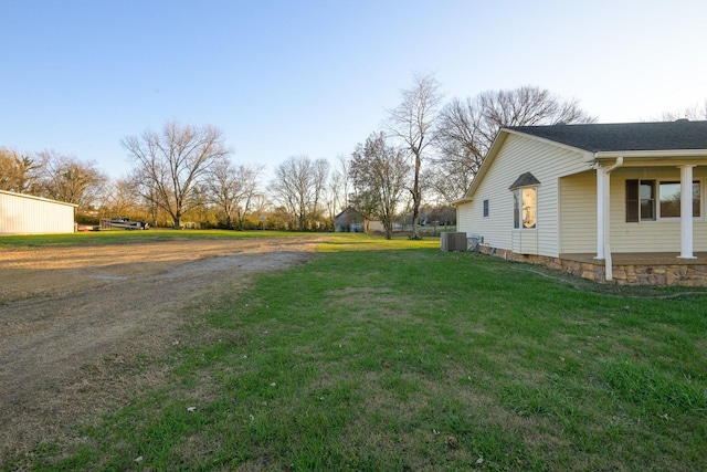 view of side of home featuring central AC unit and a yard