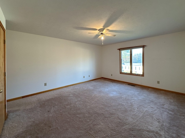 carpeted empty room with ceiling fan and a textured ceiling