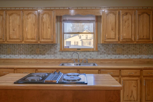 kitchen with tasteful backsplash, sink, and stainless steel gas stovetop