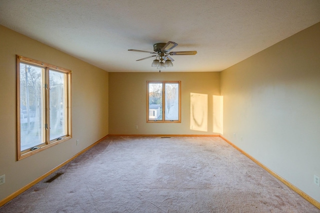 carpeted empty room featuring ceiling fan and a textured ceiling