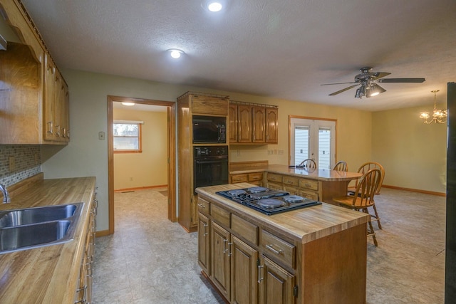 kitchen featuring butcher block counters, sink, backsplash, a textured ceiling, and black appliances