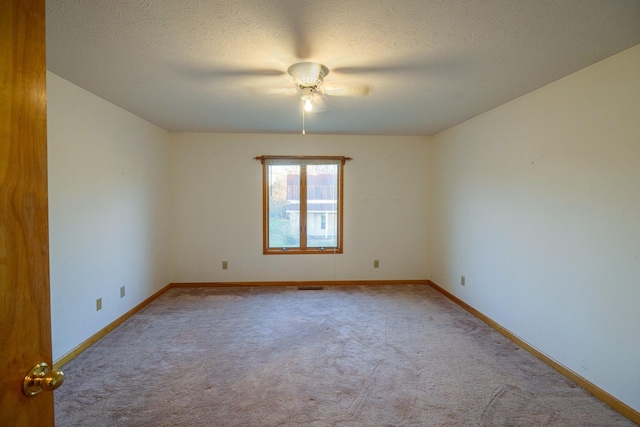 carpeted spare room with a textured ceiling