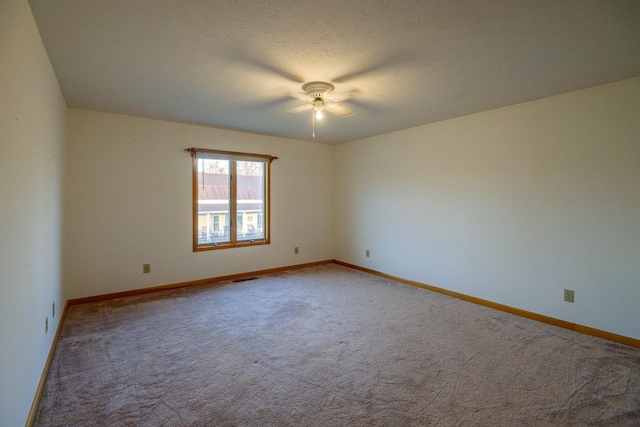 empty room with carpet and a textured ceiling