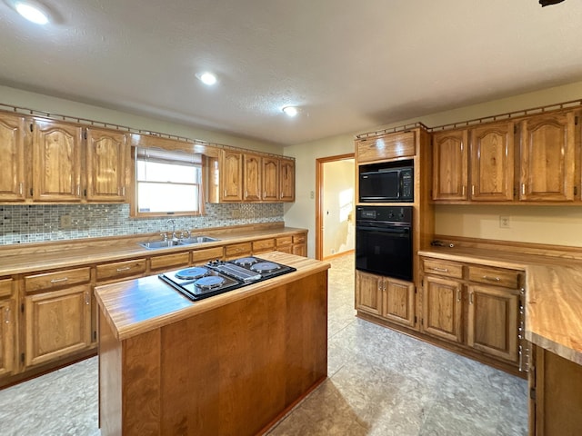 kitchen with black appliances, decorative backsplash, a center island, and sink