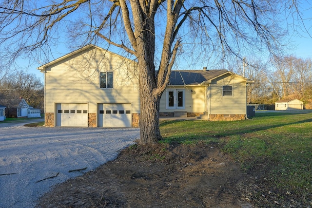 view of front of home with a garage, french doors, and a front lawn