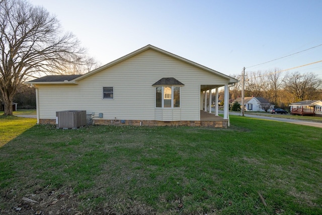 view of side of property featuring a yard and central air condition unit