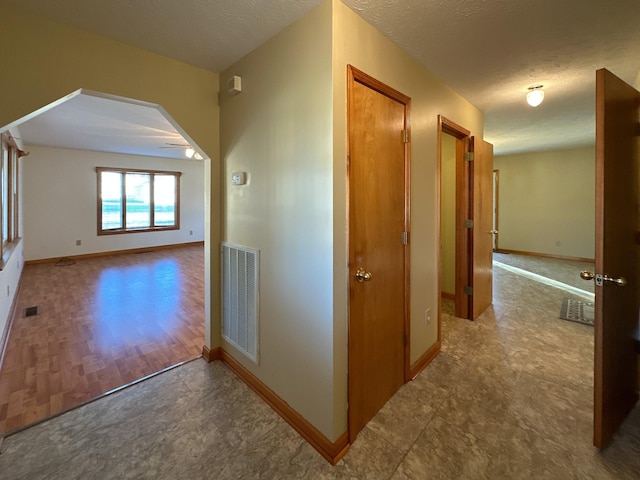 hall with hardwood / wood-style floors and a textured ceiling