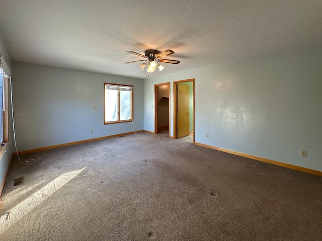 empty room featuring a textured ceiling, carpet floors, and ceiling fan