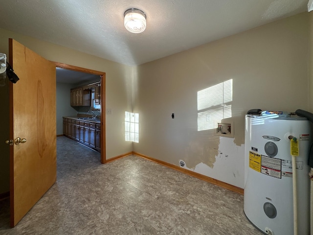 unfurnished room with a textured ceiling, electric water heater, and sink