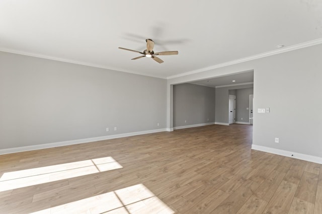 empty room with ceiling fan, ornamental molding, and light wood-type flooring