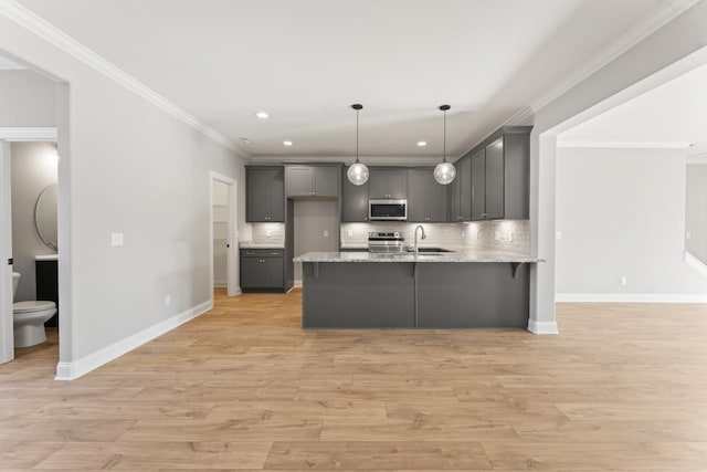 kitchen featuring gray cabinetry, hanging light fixtures, decorative backsplash, light hardwood / wood-style floors, and stainless steel appliances