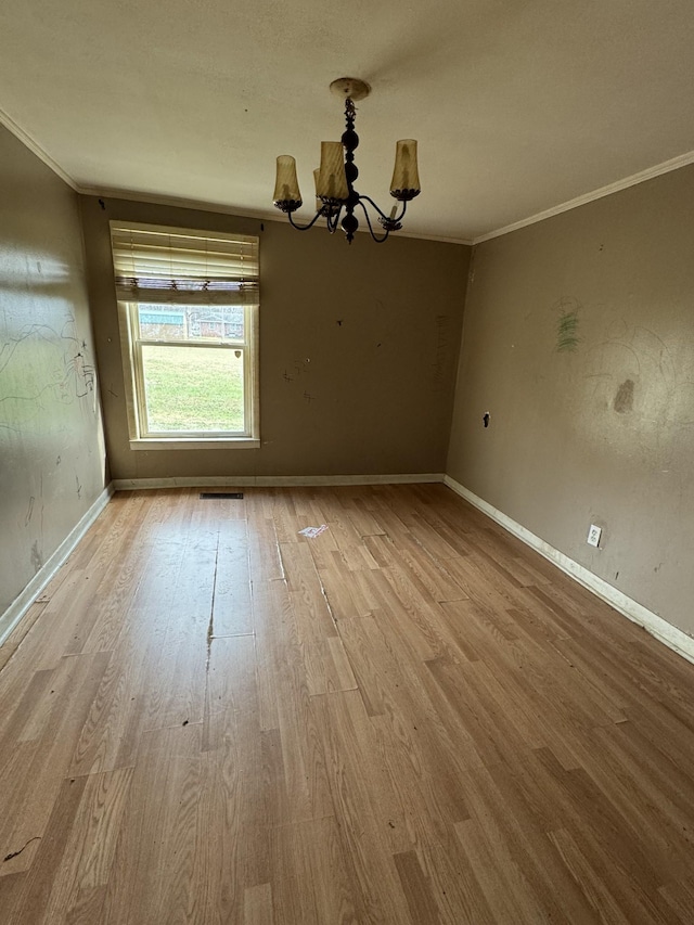 unfurnished dining area featuring a chandelier, light wood-type flooring, and ornamental molding