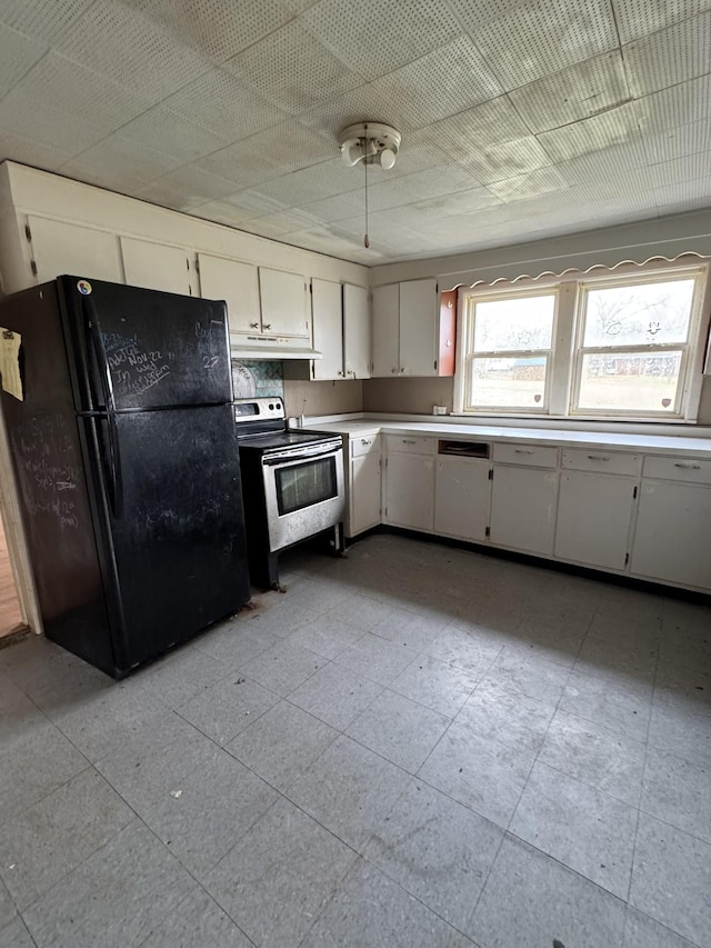 kitchen with electric range, black refrigerator, and white cabinets