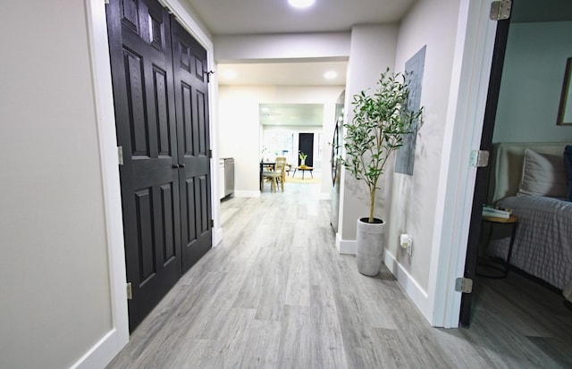 hallway with light hardwood / wood-style flooring