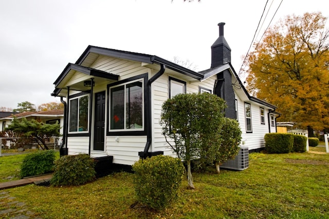 view of side of home with a yard and cooling unit