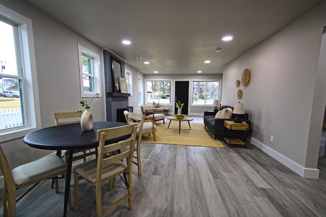 dining area featuring a fireplace, hardwood / wood-style floors, and a healthy amount of sunlight