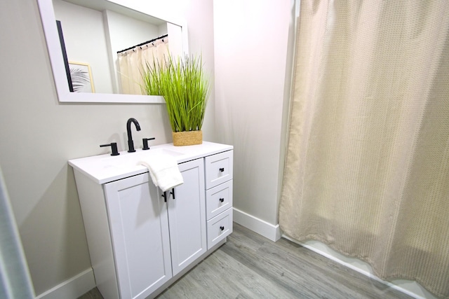 bathroom with vanity, wood-type flooring, and walk in shower