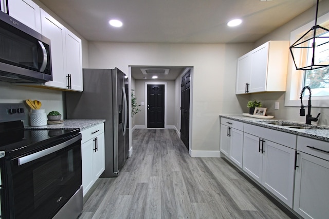 kitchen with white cabinets, light stone counters, sink, and stainless steel appliances