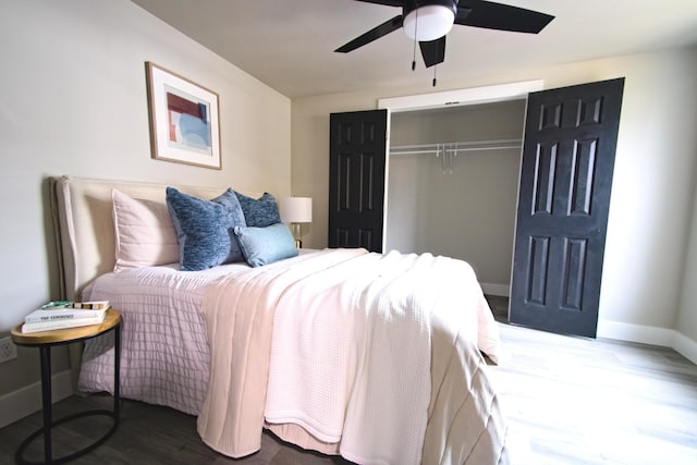 bedroom with ceiling fan, a closet, and dark wood-type flooring