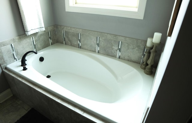 bathroom featuring tile patterned flooring and tiled tub