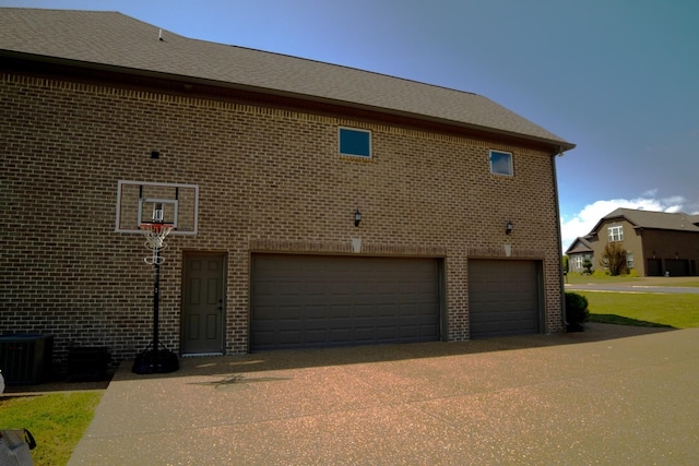 view of side of property featuring a garage and cooling unit