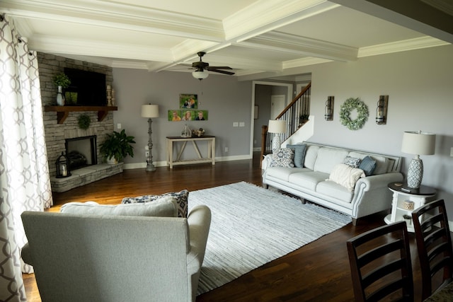 living room featuring crown molding, dark hardwood / wood-style floors, ceiling fan, a fireplace, and beam ceiling