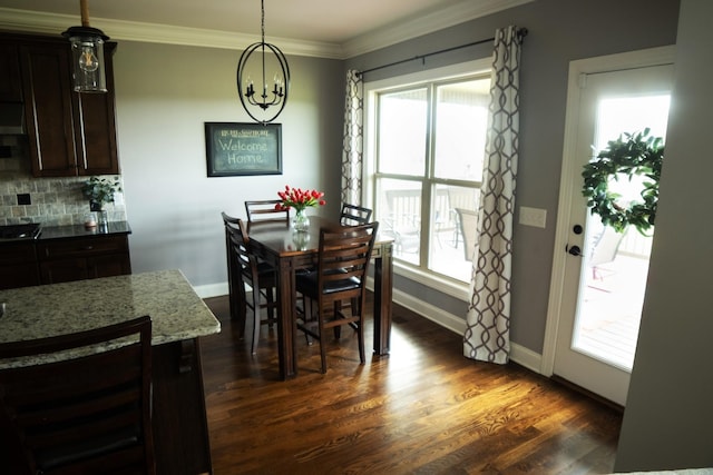 dining area featuring crown molding, dark wood-type flooring, and a notable chandelier