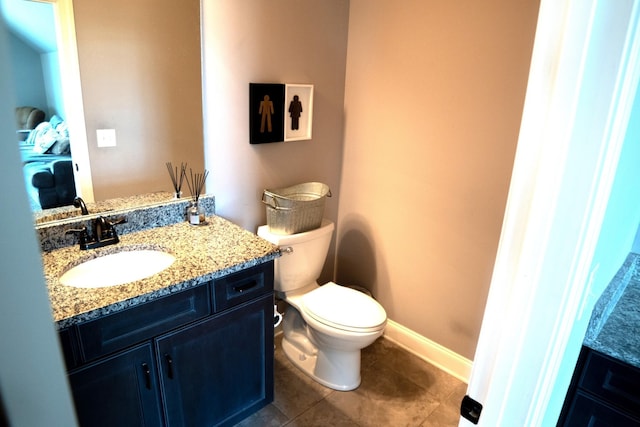 bathroom with tile patterned flooring, vanity, and toilet