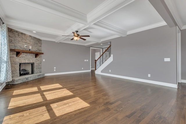 unfurnished living room with a fireplace, wood finished floors, baseboards, stairway, and beamed ceiling