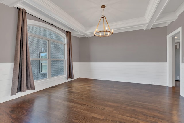 unfurnished room with coffered ceiling, a wainscoted wall, an inviting chandelier, and wood finished floors