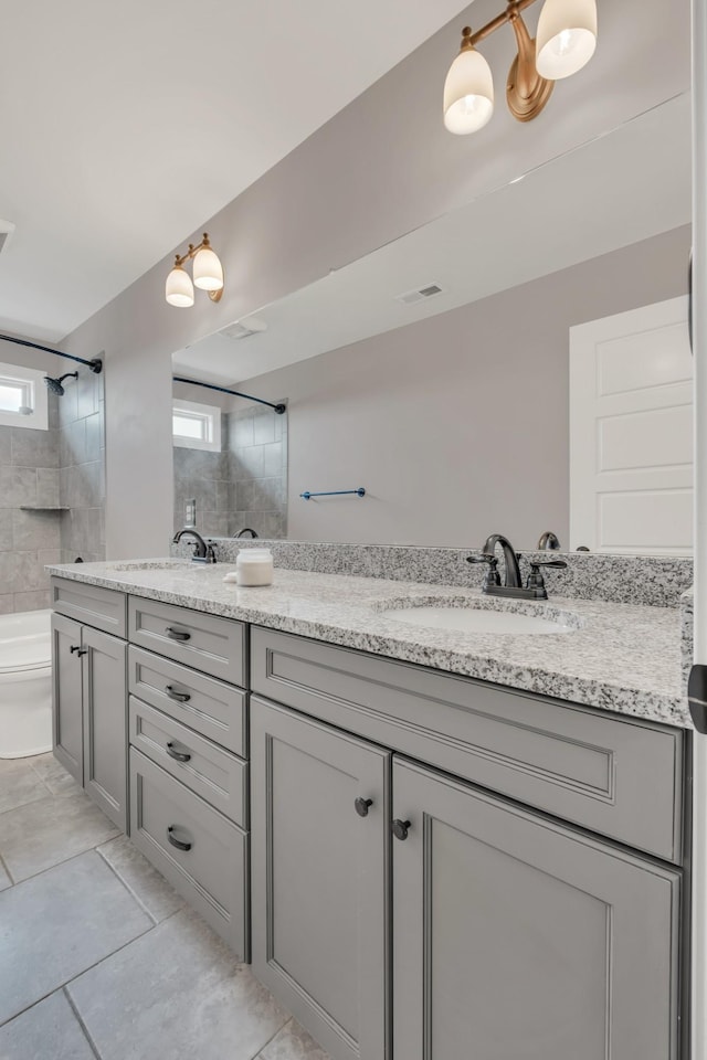 full bathroom featuring visible vents, a sink, and double vanity