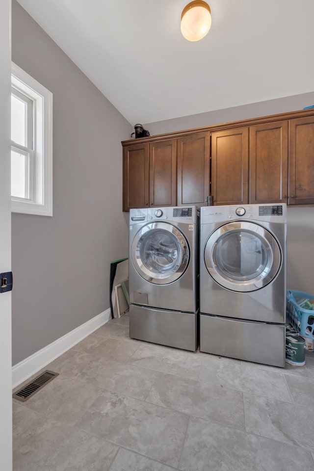 laundry room featuring cabinet space, baseboards, visible vents, and washer and clothes dryer