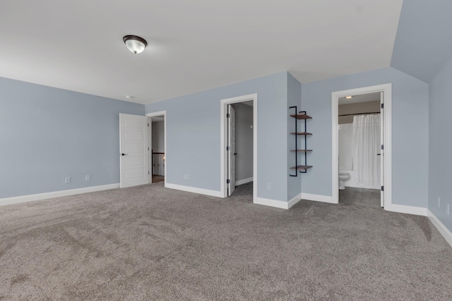 unfurnished bedroom featuring connected bathroom, baseboards, a walk in closet, and carpet flooring