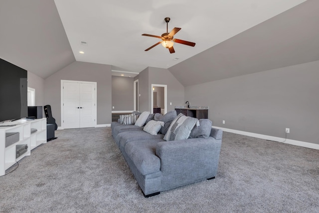 living area featuring vaulted ceiling, baseboards, a ceiling fan, and light colored carpet