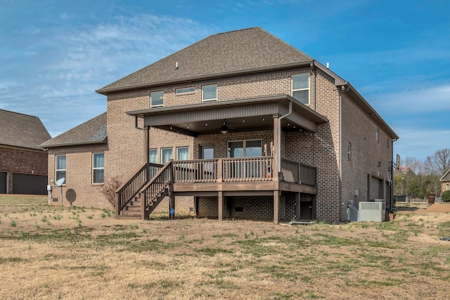 rear view of property with brick siding, roof with shingles, a ceiling fan, a deck, and a garage