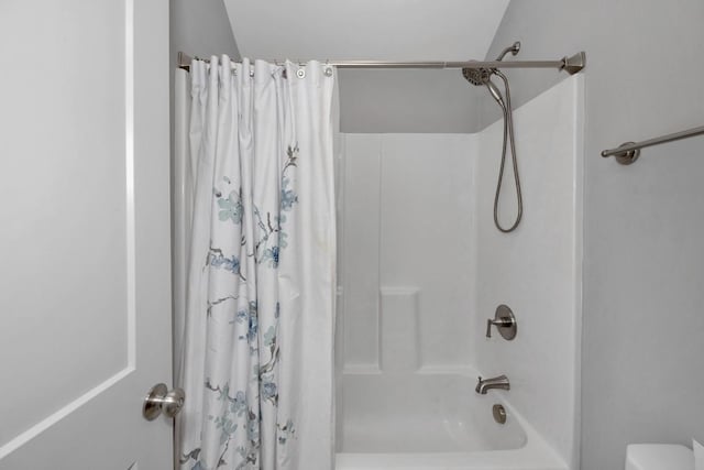 bathroom with vaulted ceiling and shower / tub combo