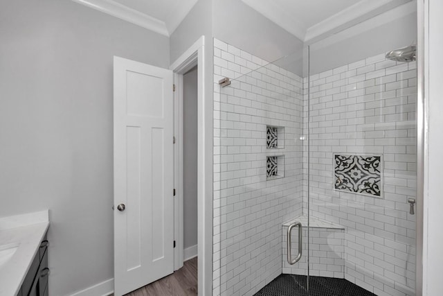 bathroom with vanity, hardwood / wood-style flooring, a shower with door, and ornamental molding