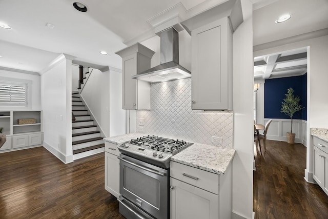 kitchen with wall chimney range hood, stainless steel gas range, light stone countertops, beam ceiling, and dark hardwood / wood-style flooring