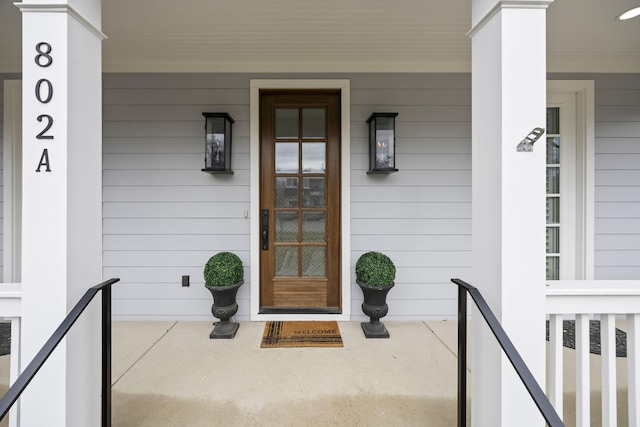 view of exterior entry featuring covered porch