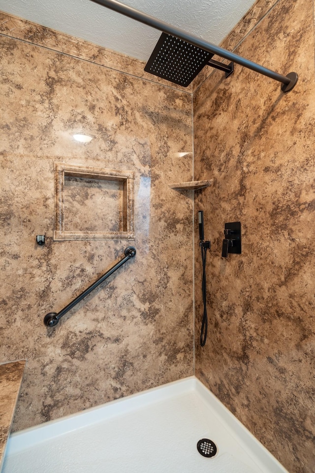 bathroom with a tile shower and a textured ceiling