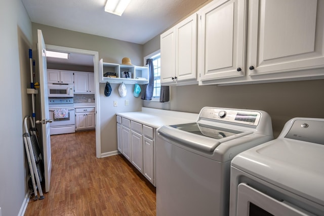 laundry area featuring washer and dryer, dark hardwood / wood-style flooring, and cabinets