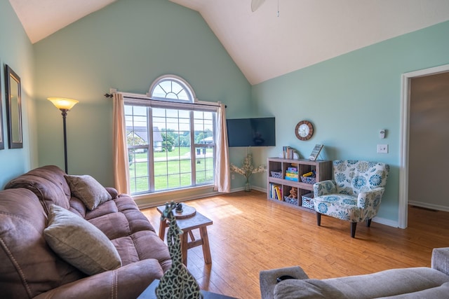 living room featuring high vaulted ceiling, light hardwood / wood-style flooring, and ceiling fan